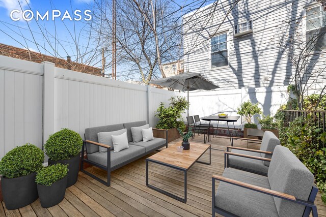 deck with outdoor lounge area, a fenced backyard, and outdoor dining area
