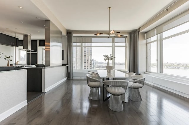 dining space featuring baseboards, a chandelier, and dark wood-type flooring