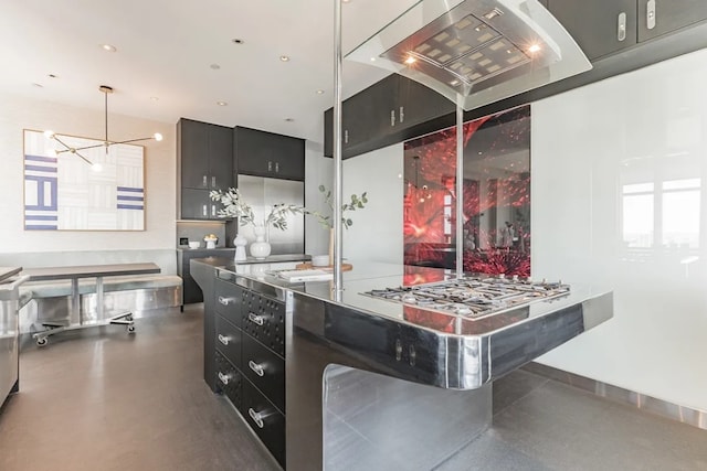 kitchen with dark cabinets, pendant lighting, finished concrete floors, exhaust hood, and a chandelier