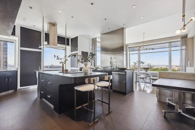 kitchen with island range hood, stainless steel dishwasher, a center island, dark cabinets, and decorative light fixtures