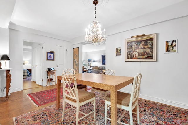 dining room featuring a chandelier and baseboards