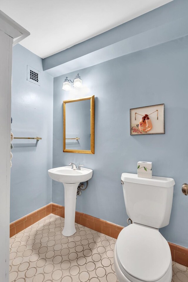 bathroom with toilet and baseboards