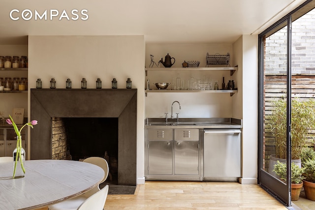 indoor wet bar featuring stainless steel dishwasher and light wood finished floors