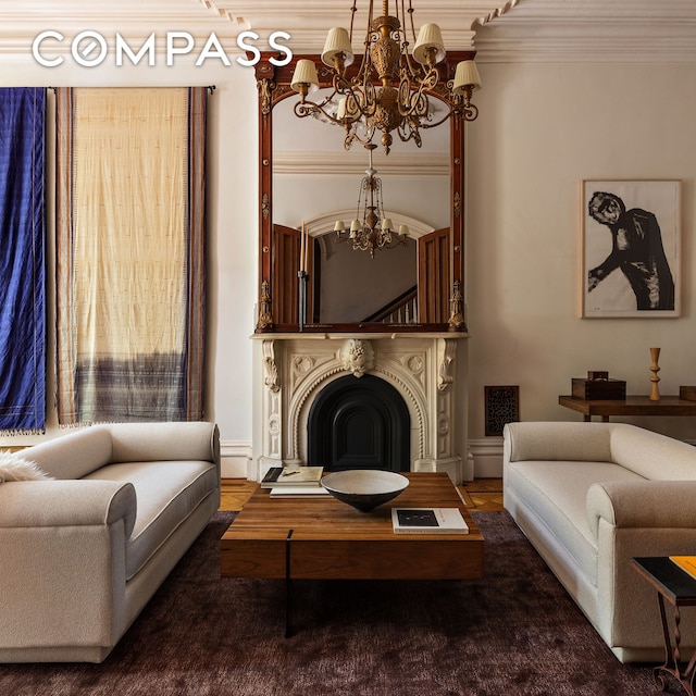 living room with a chandelier, ornamental molding, and a fireplace