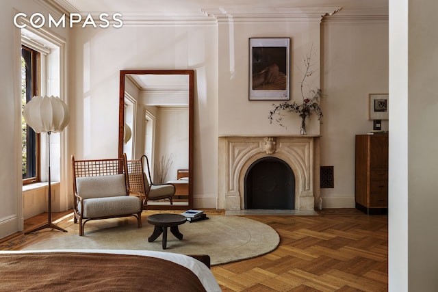 living area with crown molding, a premium fireplace, and baseboards