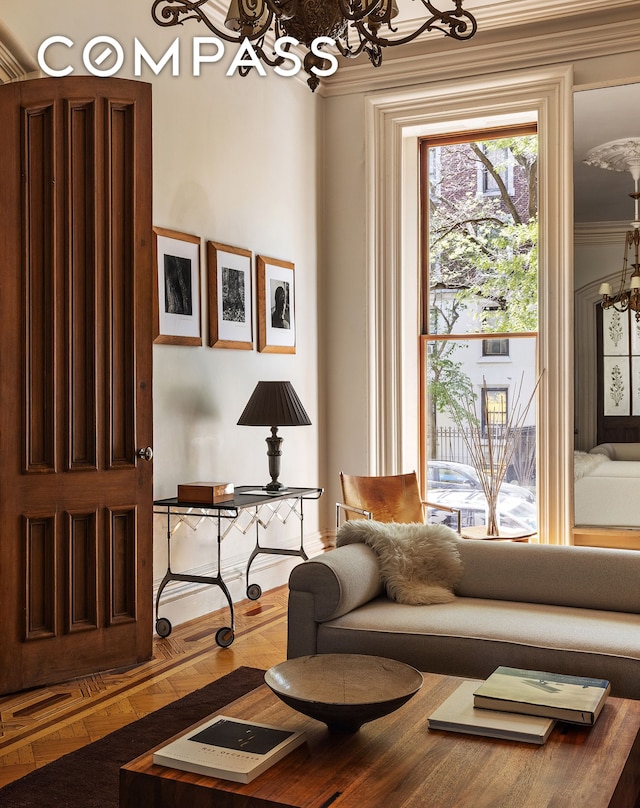 sitting room with a chandelier and crown molding
