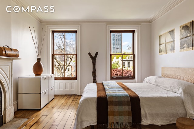 bedroom with light wood-type flooring and crown molding