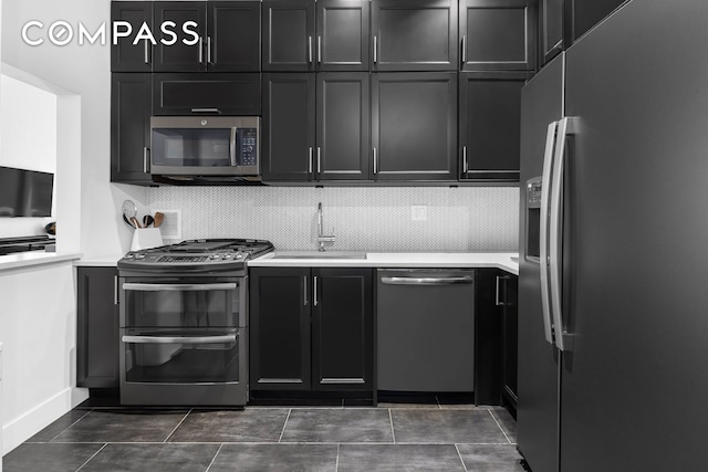 372 5th Ave Unit 5F, New York City, NY 10018 - kitchen with appliances with stainless steel finishes, dark cabinetry, light countertops, and backsplash