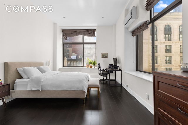 372 5th Ave Unit 5F, New York City, NY 10018 - bedroom with multiple windows, dark wood-type flooring, a desk, and a wall mounted air conditioner