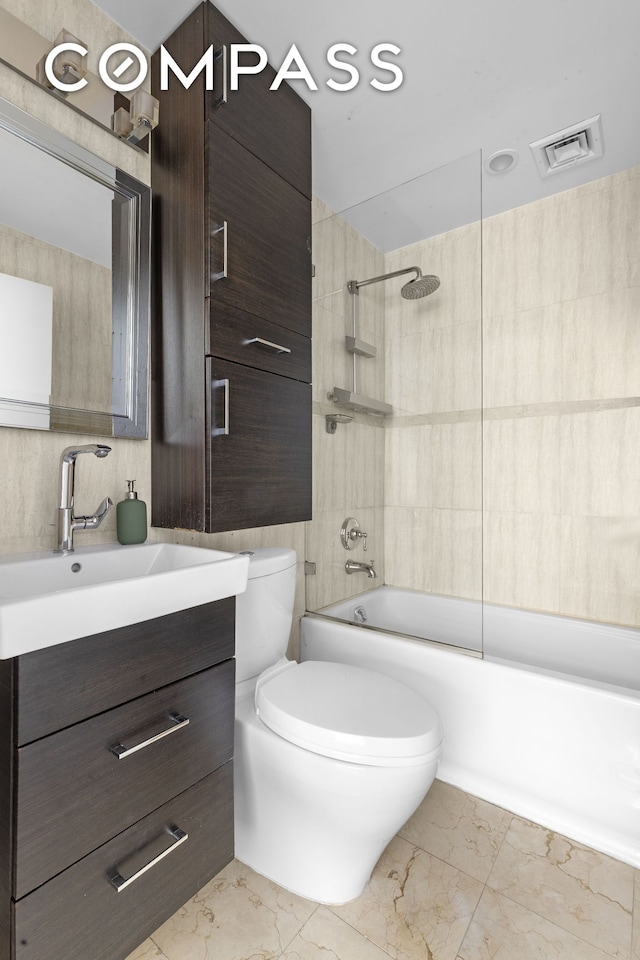 372 5th Ave Unit 5F, New York City, NY 10018 - full bathroom with marble look tiles, vanity, and shower / bath combination