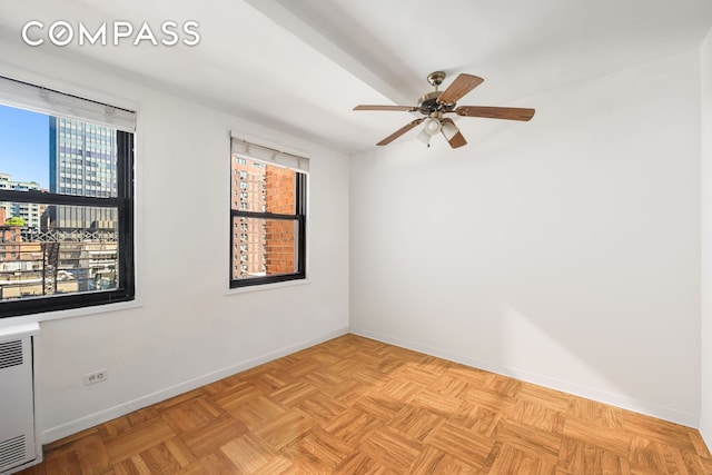 347 E 53rd St Unit 9C, New York City, NY 10022 - spare room featuring healthy amount of natural light, baseboards, a ceiling fan, and a city view