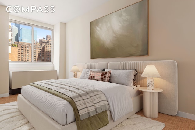 bedroom featuring a view of city and baseboards