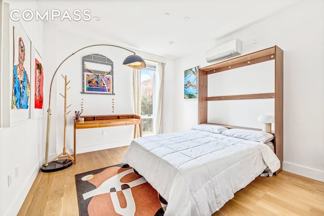 1404 Bushwick Ave Unit 1R, New York City, NY 11207 - bedroom featuring a wall mounted AC, wood finished floors, and baseboards