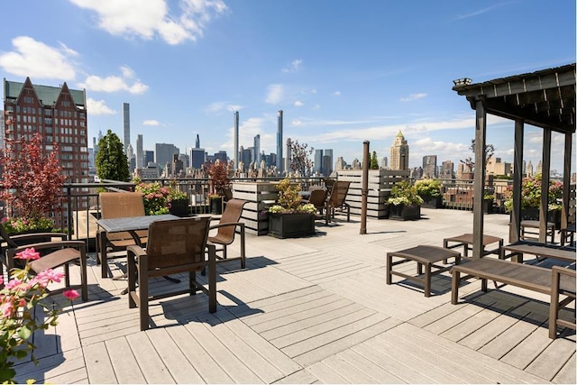 wooden deck with a view of skyline and outdoor dining area