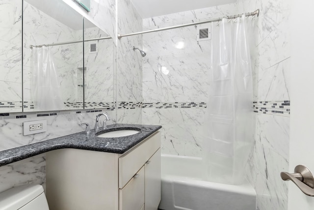 full bathroom featuring shower / bath combo with shower curtain, vanity, toilet, and tile walls