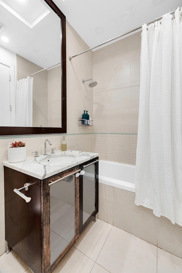 full bathroom featuring tile patterned flooring, tiled shower / bath, and vanity