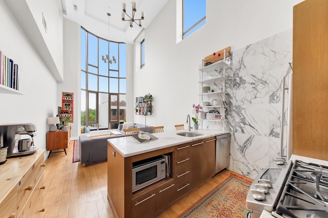 200 16th St Unit 4A, New York City, NY 11215 - kitchen with stainless steel appliances, a chandelier, a towering ceiling, plenty of natural light, and light wood finished floors