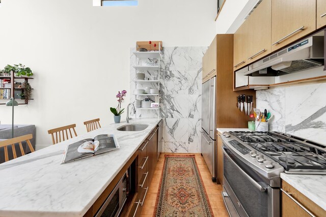 200 16th St Unit 4A, New York City, NY 11215 - kitchen with appliances with stainless steel finishes, under cabinet range hood, a peninsula, tasteful backsplash, and light stone countertops