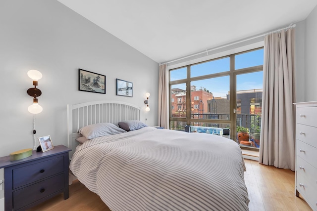 bedroom with vaulted ceiling and light wood-type flooring