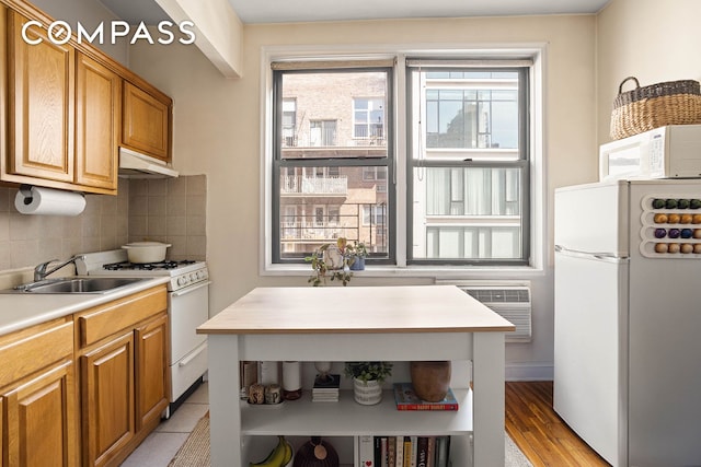 148 E 84th St Unit 4A, New York City, NY 10028 - kitchen with white appliances, open shelves, under cabinet range hood, light countertops, and decorative backsplash