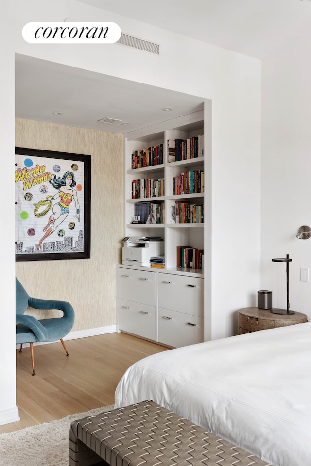 bedroom featuring wallpapered walls, light wood finished floors, and baseboards