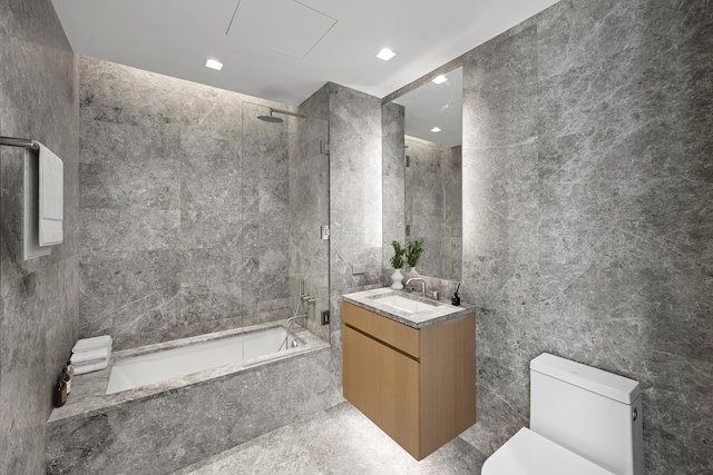 bathroom with tile walls, toilet, and vanity