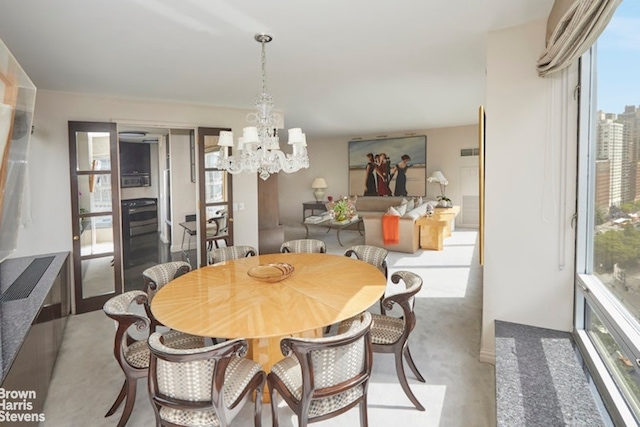 dining room with light carpet and a chandelier