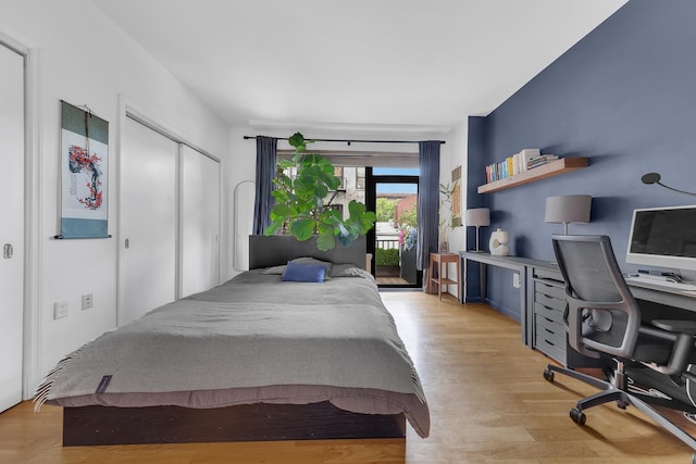 bedroom featuring access to outside, light wood-style floors, a desk, and a closet
