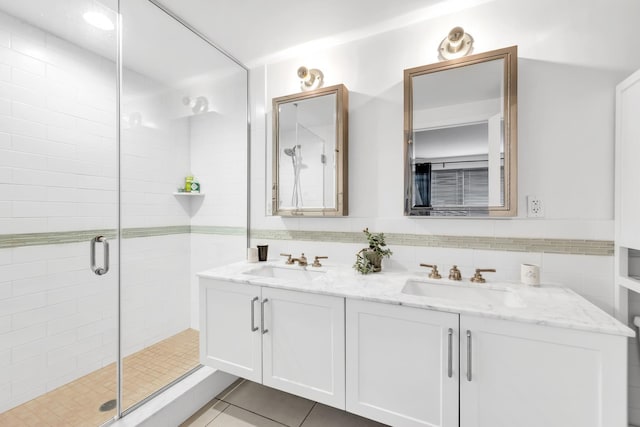 bathroom with a shower stall and double vanity