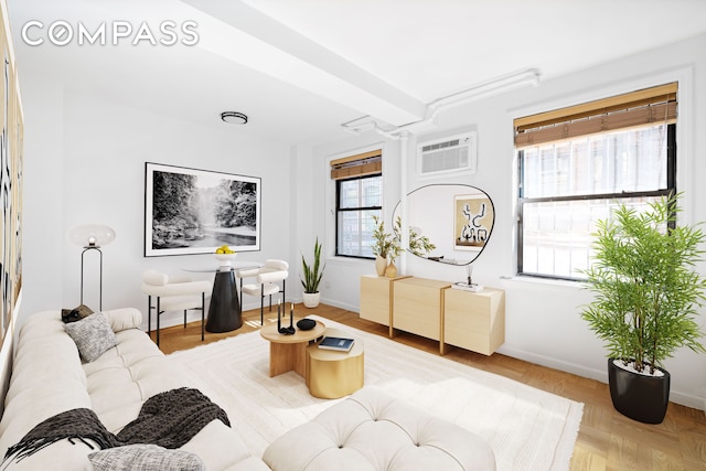 living area featuring baseboards and a wall mounted air conditioner