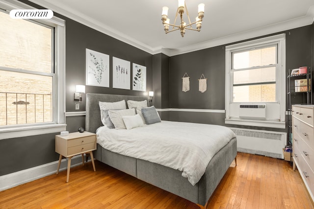 bedroom featuring radiator, a chandelier, wood finished floors, crown molding, and cooling unit