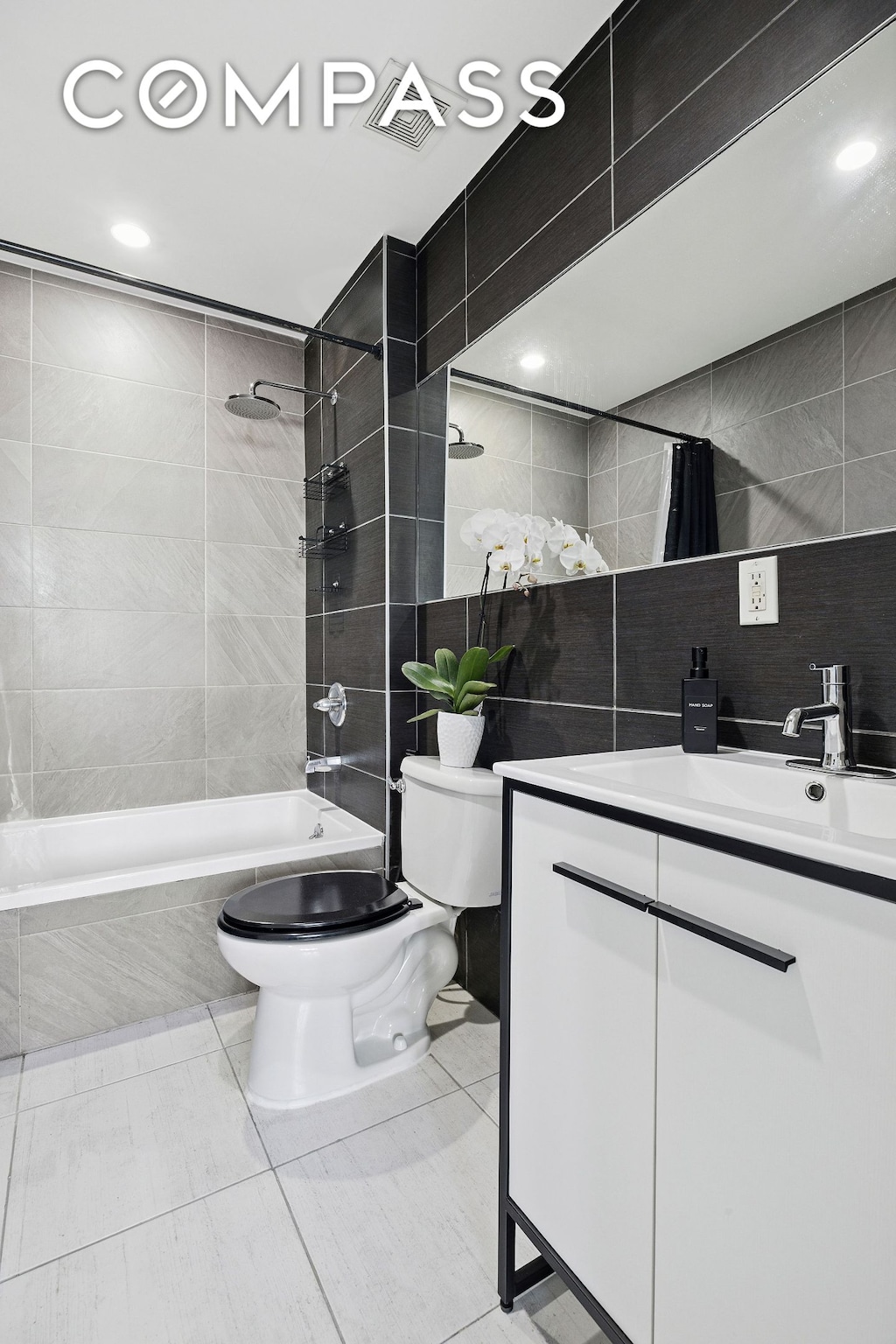 280 Nassau Ave Unit 1A, New York City, NY 11222 - bathroom featuring toilet, tile walls, vanity, tiled shower / bath, and tile patterned floors