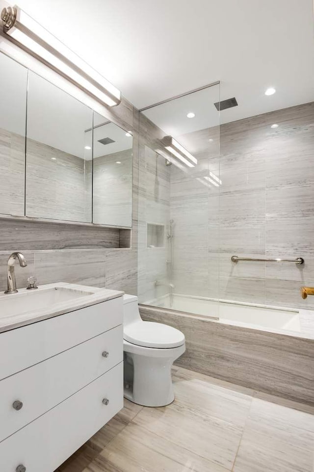 475 Park Ave Unit 15A, New York City, NY 10022 - bathroom featuring tile walls, shower / bath combination, toilet, vanity, and recessed lighting