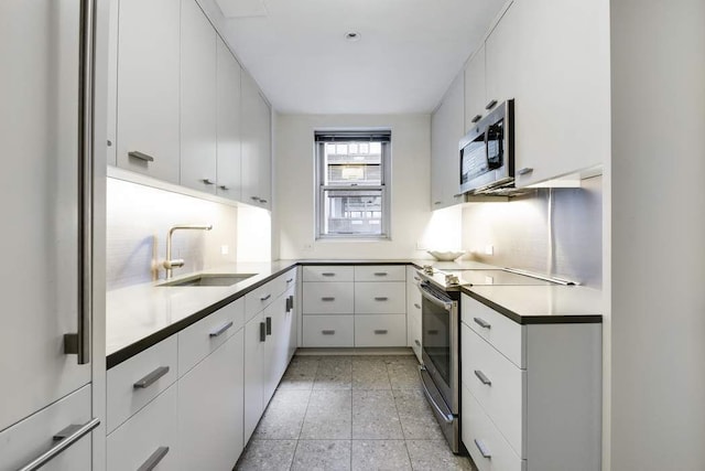 475 Park Ave Unit 15A, New York City, NY 10022 - kitchen featuring appliances with stainless steel finishes, a sink, and white cabinets