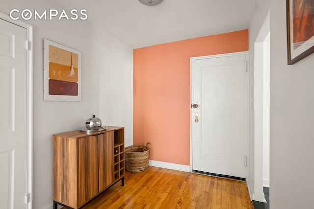 foyer entrance with light wood-style flooring and baseboards