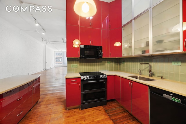 16 E 17th St Unit 3, New York City, NY 10003 - kitchen featuring red cabinets, black appliances, a sink, and backsplash