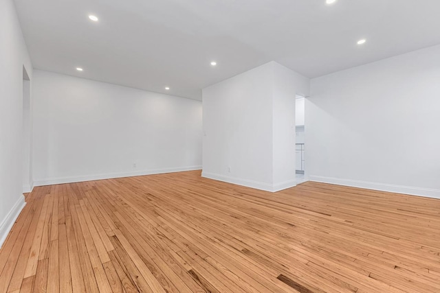 unfurnished room featuring light wood finished floors, baseboards, and recessed lighting
