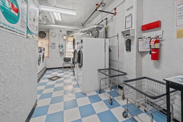 3601 Johnson Ave Unit 5K, New York City, NY 10463 - communal laundry room with washer and dryer, tile patterned floors, and a textured wall