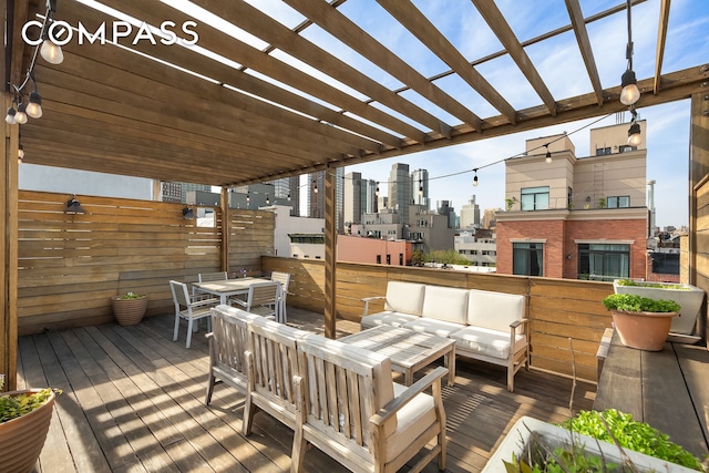 deck with a skyline view, an outdoor living space, a pergola, and outdoor dining area