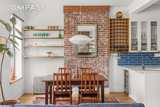 dining space with radiator and light wood-style floors