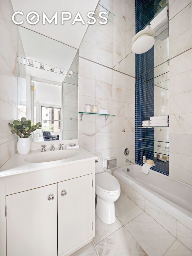 bathroom featuring tile walls, vanity, toilet, and tile patterned flooring