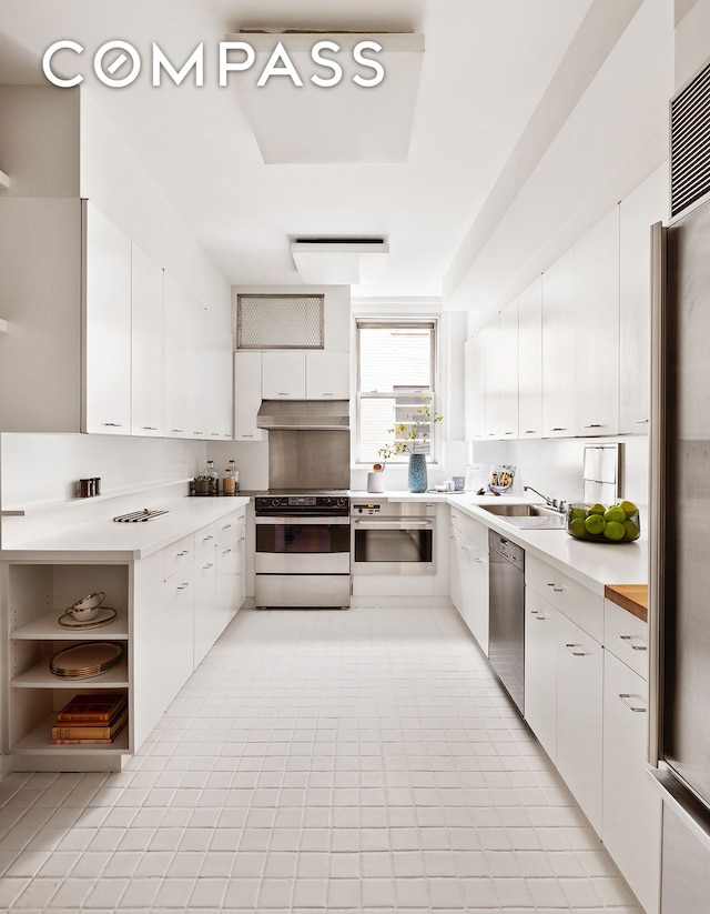 kitchen with stainless steel appliances, under cabinet range hood, white cabinets, light countertops, and a sink