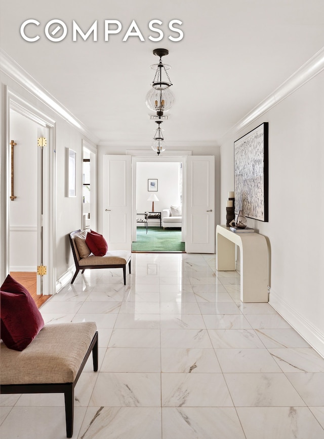 living area with marble look tiles, baseboards, and crown molding