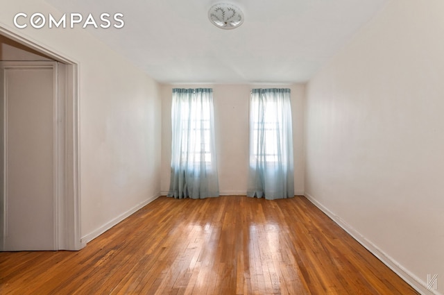 unfurnished room featuring wood-type flooring and baseboards