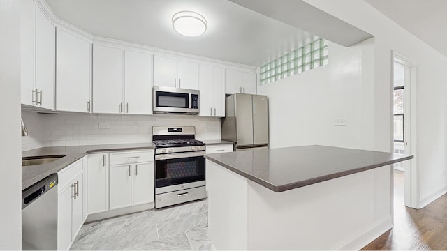 599 E 7th St Unit 2B, New York City, NY 11218 - kitchen with stainless steel appliances, dark countertops, decorative backsplash, and white cabinetry