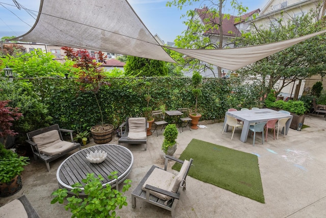 view of patio featuring outdoor dining space and fence