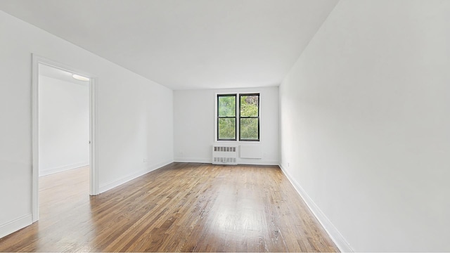 599 E 7th St Unit 2B, New York City, NY 11218 - spare room featuring radiator heating unit, hardwood / wood-style flooring, and baseboards