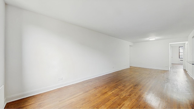 spare room featuring light wood-style floors and baseboards