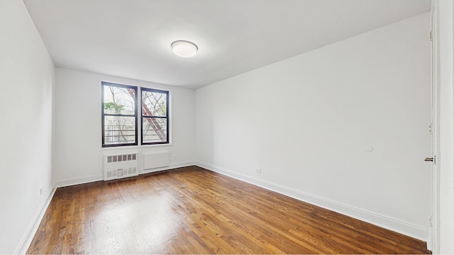 599 E 7th St Unit 2B, New York City, NY 11218 - spare room with radiator heating unit, wood finished floors, and baseboards