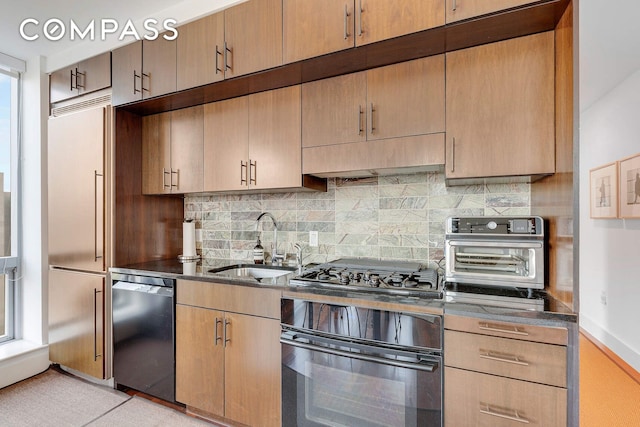 kitchen featuring oven, dishwashing machine, a sink, backsplash, and stainless steel gas cooktop